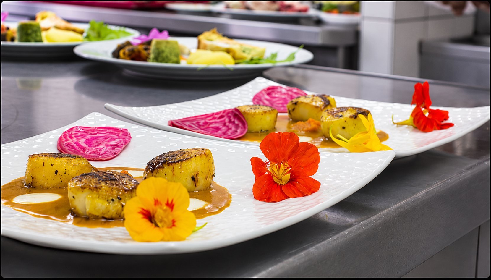 Assiettes de Saint-Jacques dorées et fleurs comestibles