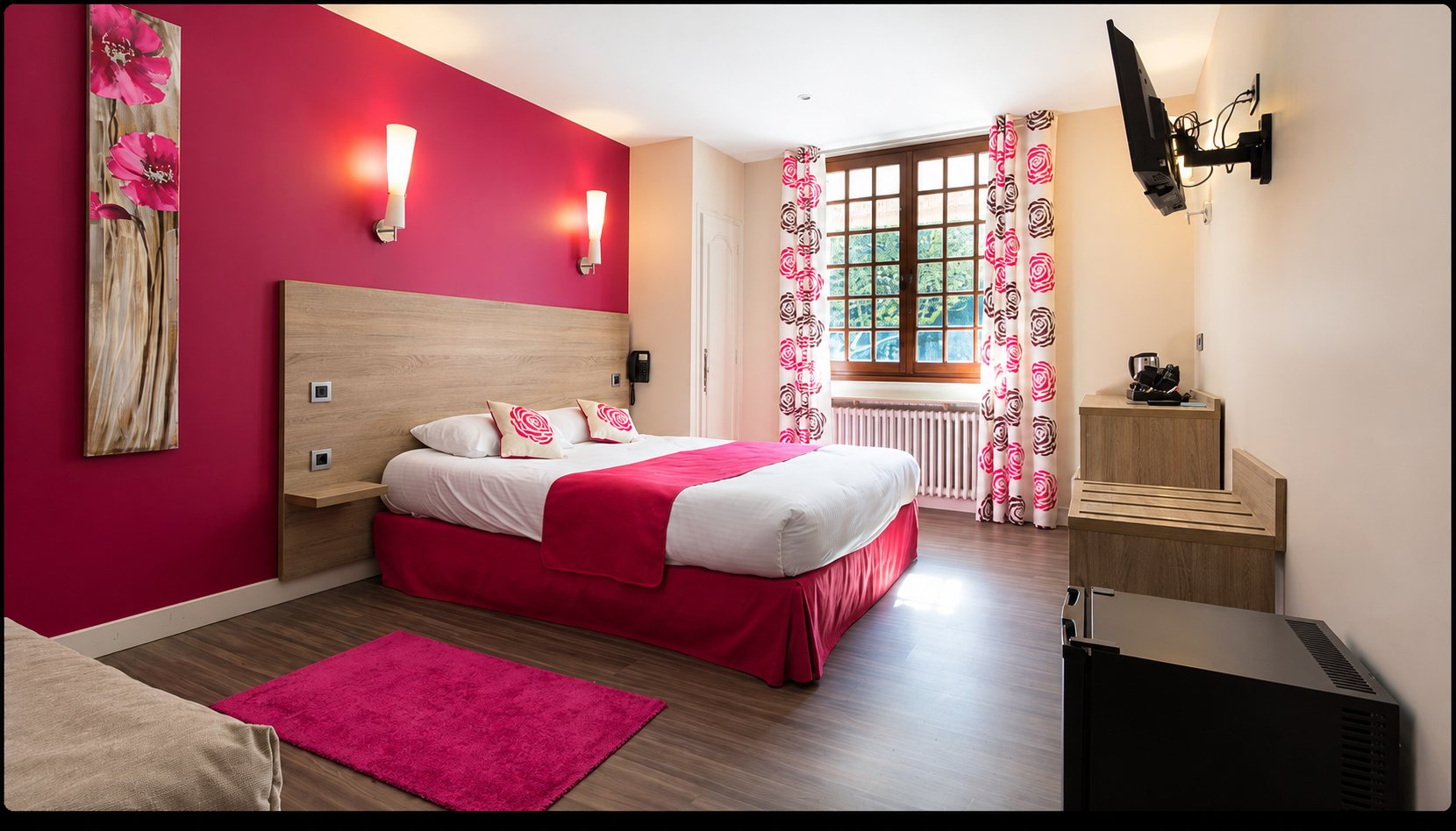Chambre d'hôtel avec lit double et rideaux à motifs de roses