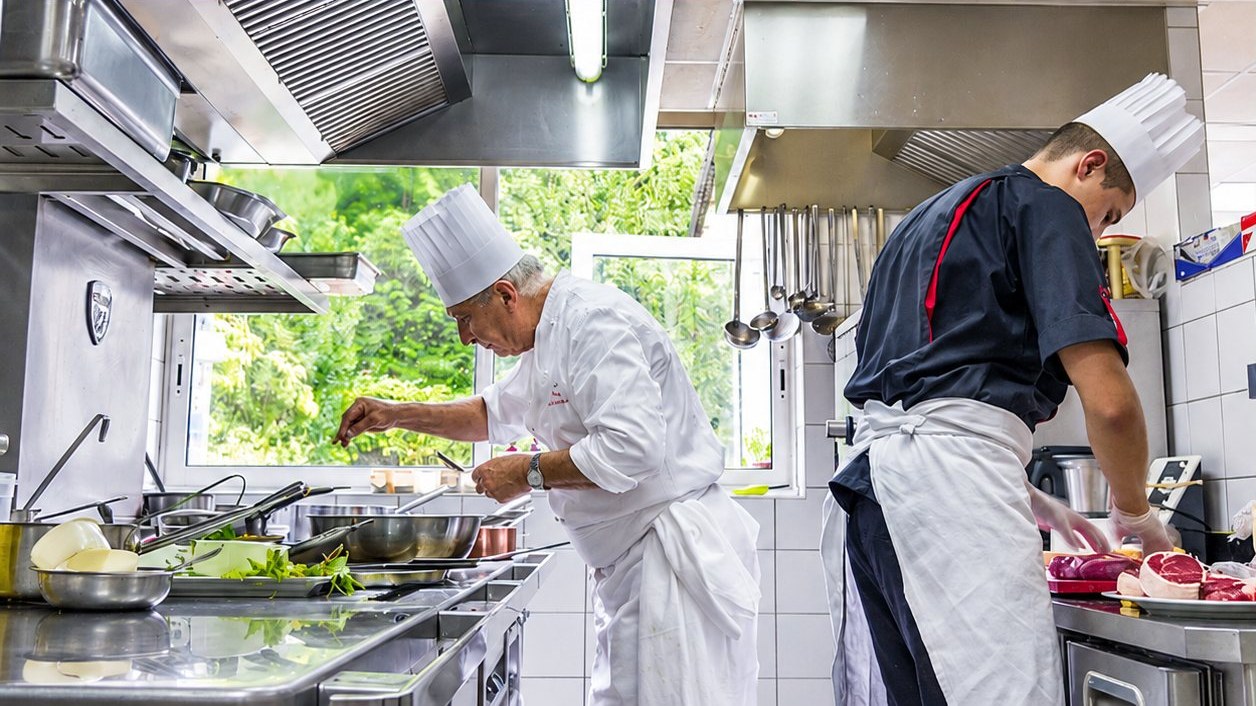 Deux cuisiniers en tenue dans la cuisine du restaurant